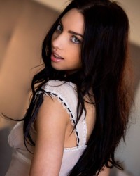 Красивая девушка раздевается в спальне Красивая девушка раздевается в спальне